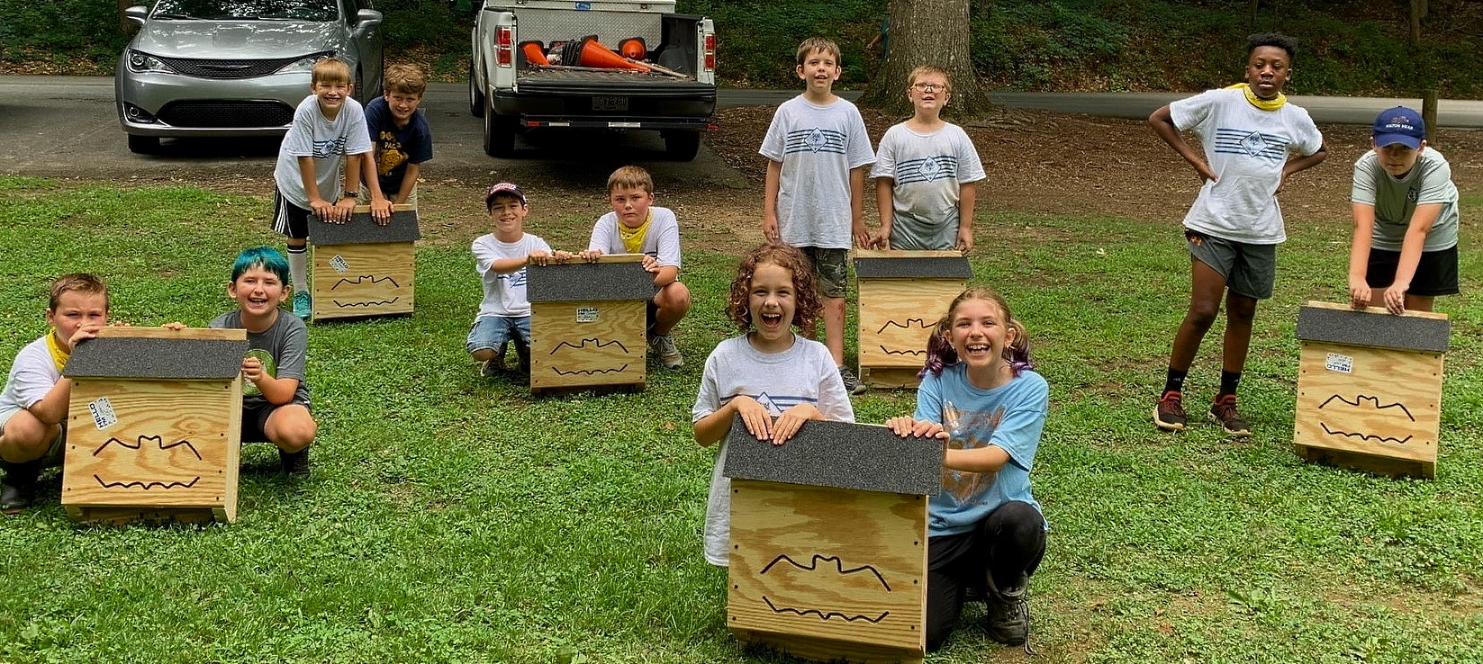 Children posing with the bat houses they made for a city project.