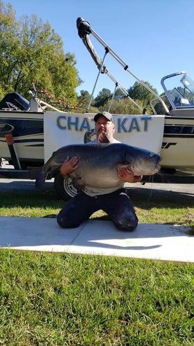 Angler with large catfish in front of boat