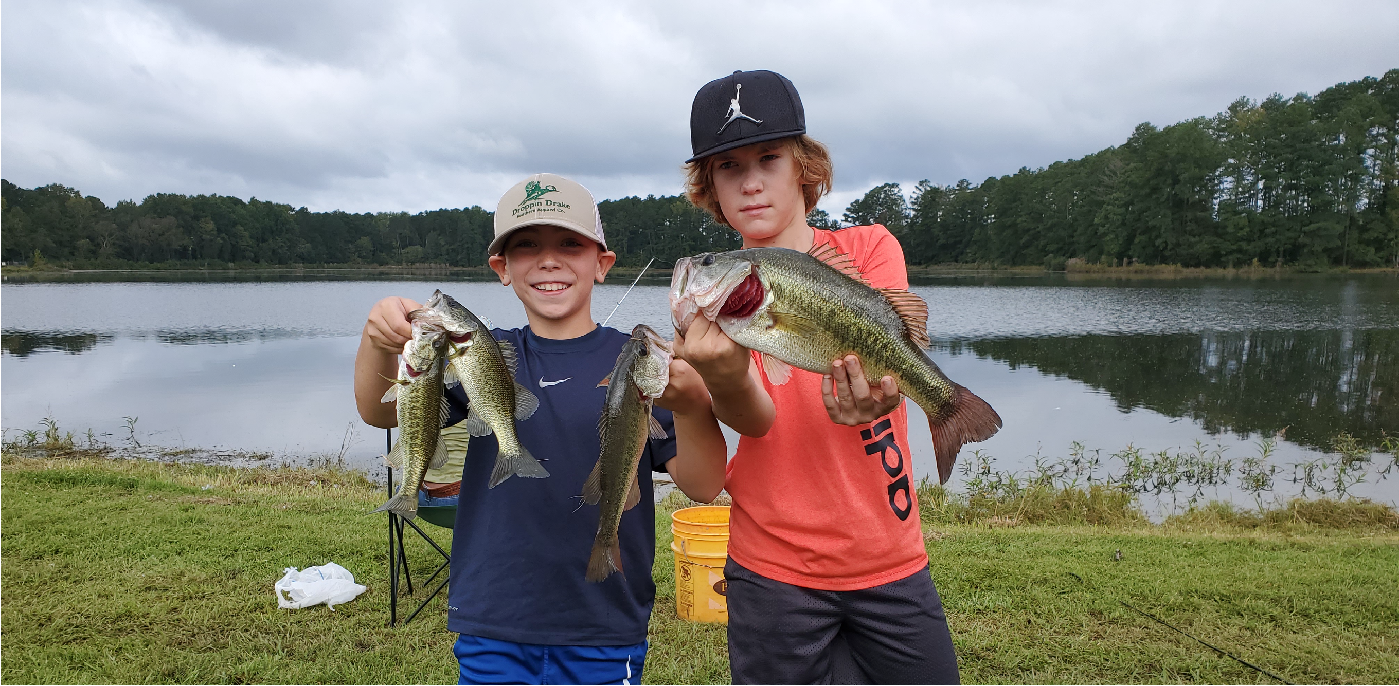 Two boys hold up fish