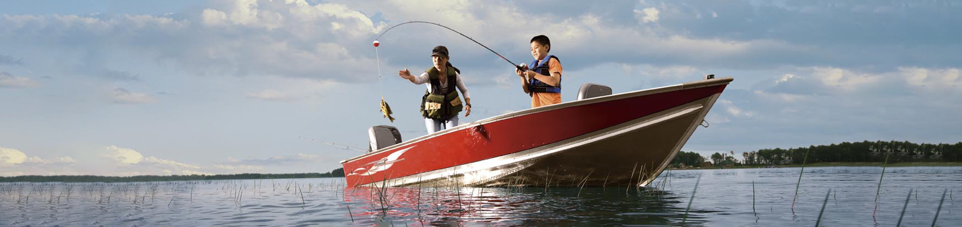 Mom and son fishing off boat
