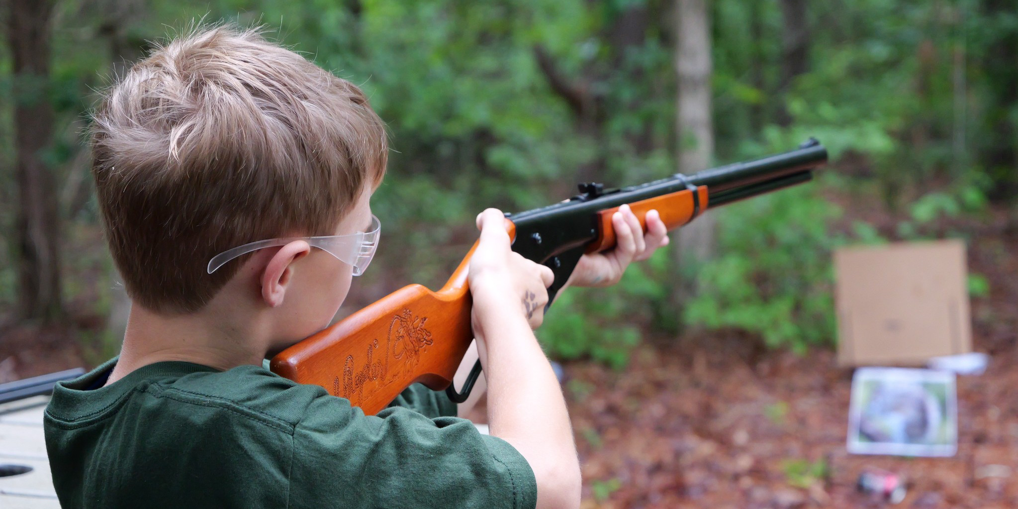 Boy aiming a rifle.