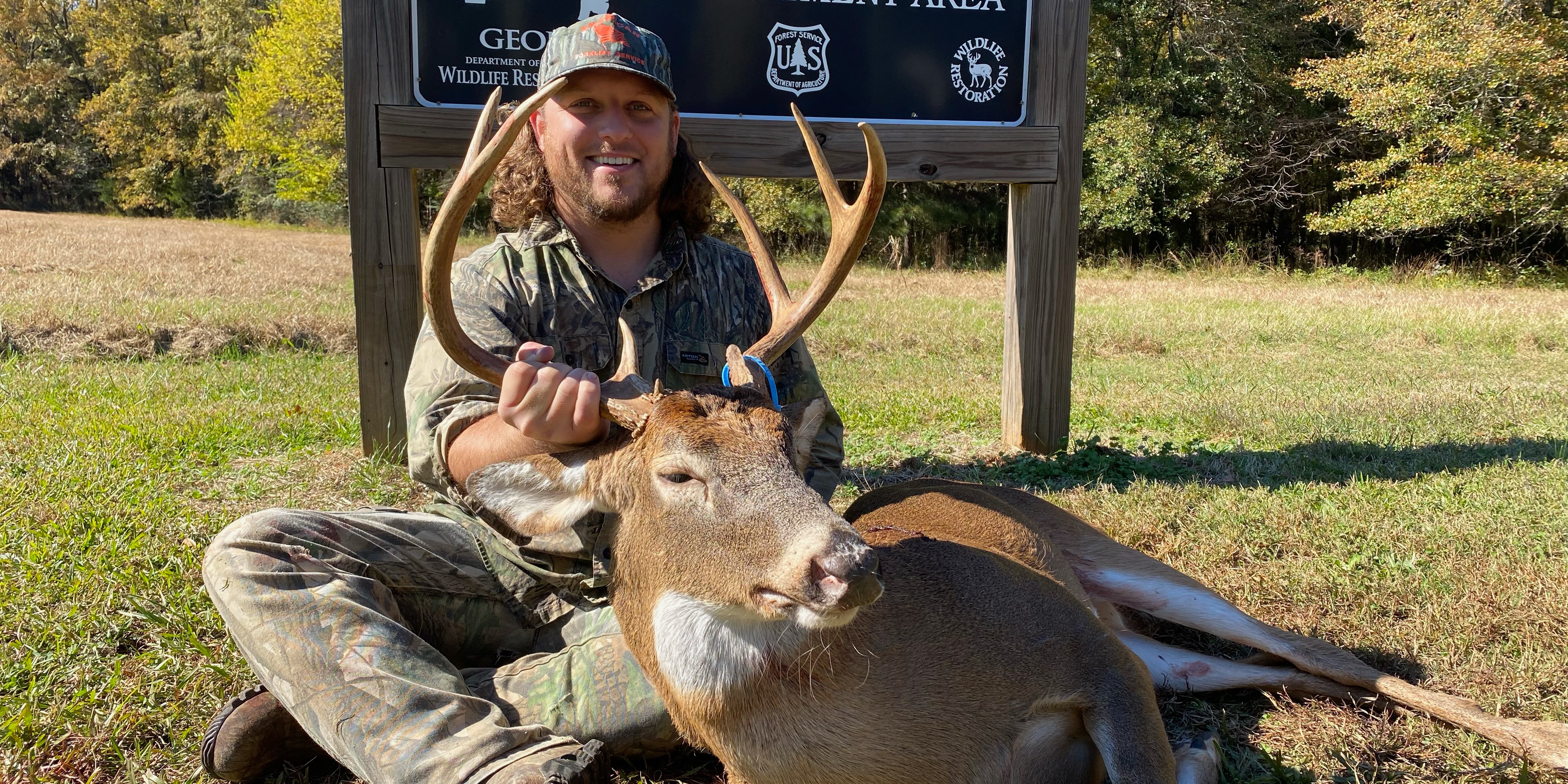A man poses with a deer he hunted.