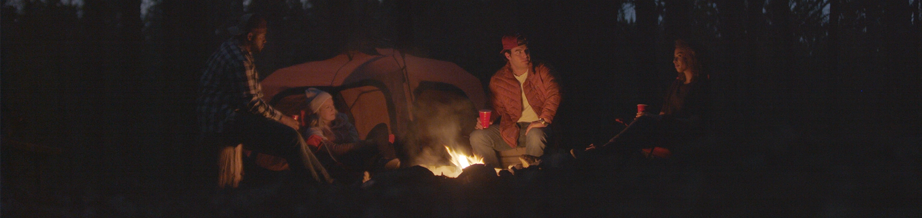 Friends sitting around a campfire together
